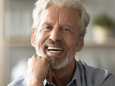 An older man pleased with his dentures
