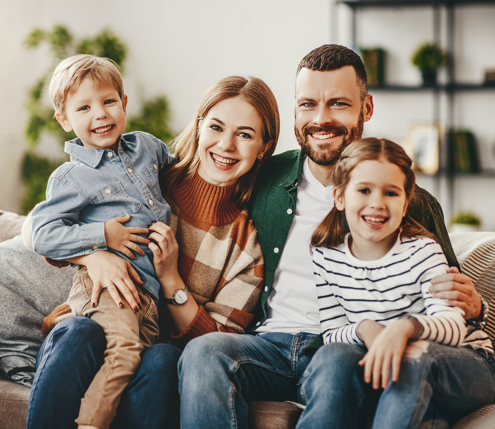 Family sitting on couch together and smiling