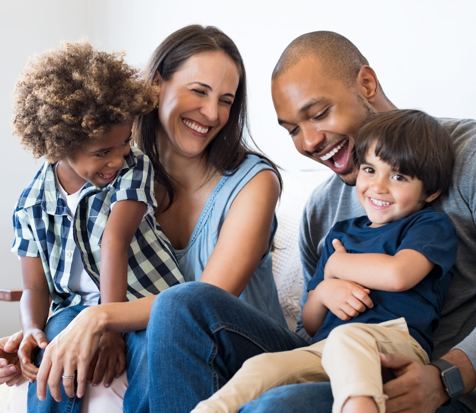 Family sitting on couch together and smiling