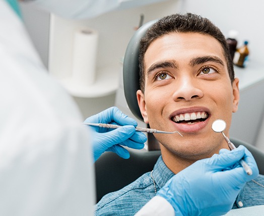 a man having his teeth examined by an orthodontist